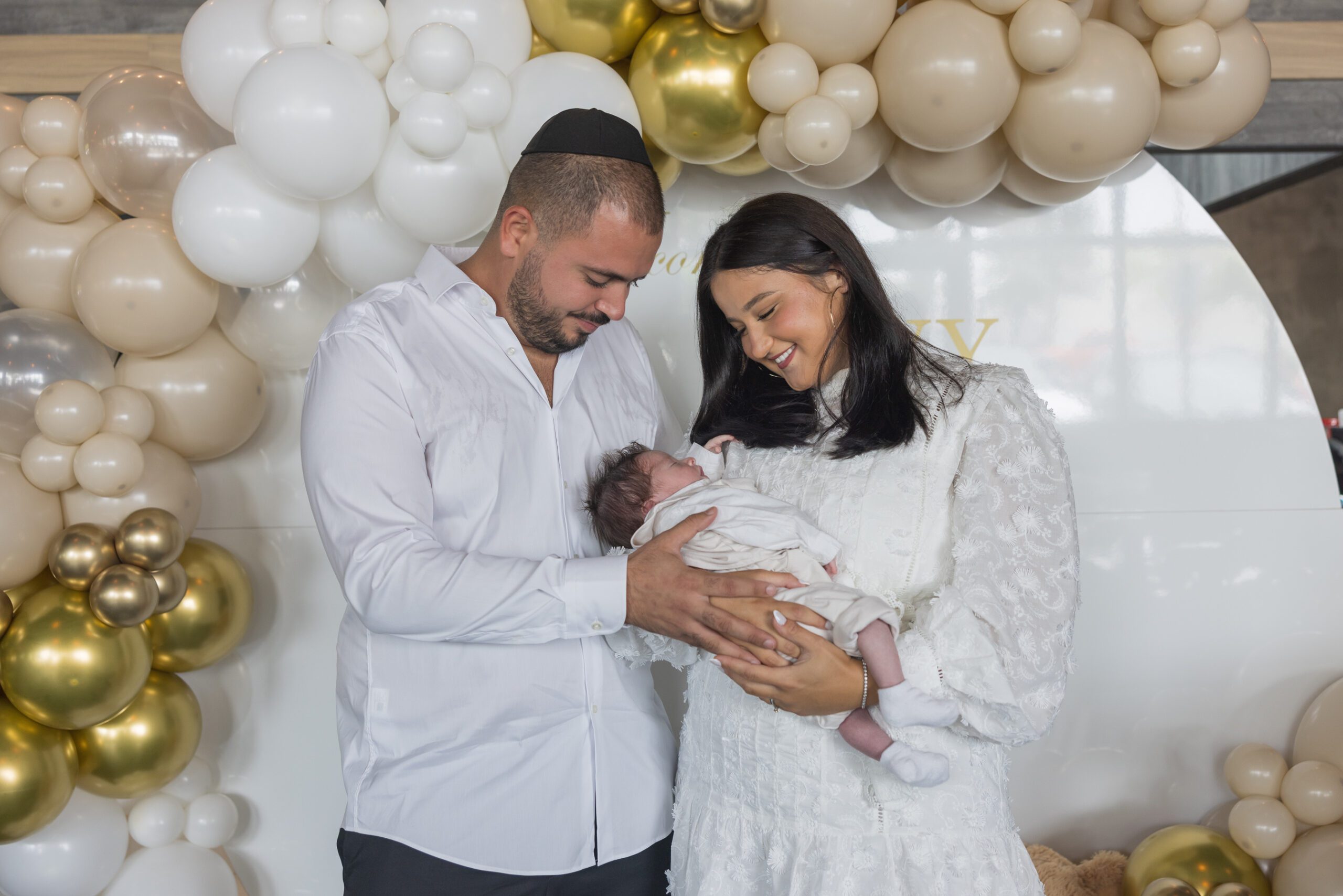 Couple holding baby at South Florida Event; baptism